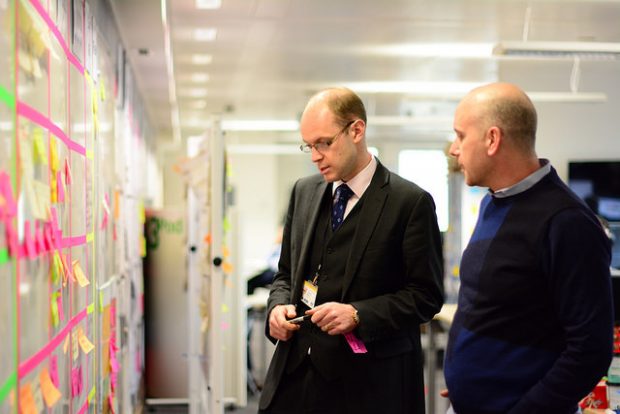 Senior policy advisor James Reeve with a colleague looking at a wall of post-it notes