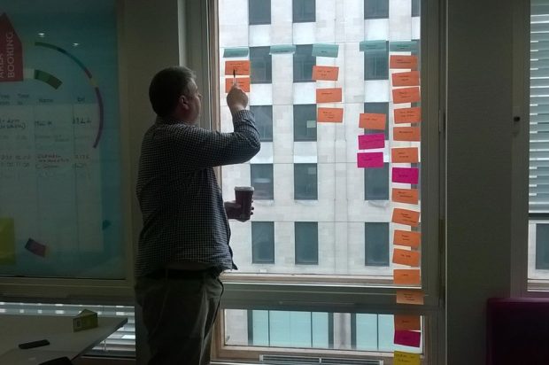 Mark Dalgarno (delivery manager at the Department for Education) looking at notes written on post-its