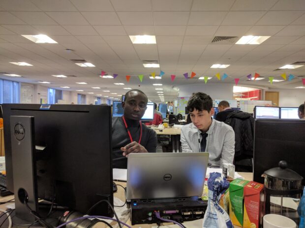 Arun and Kola workng together on a computer at a desk