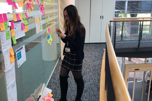 A typical day of a user researcher showing Lydia working on the User research wall in the office 