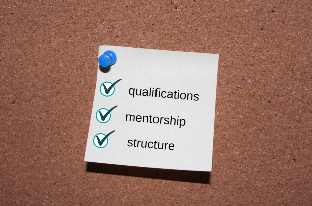 A note pinned to a noticeboard with the words qualifications, mentorship and structure written as a list