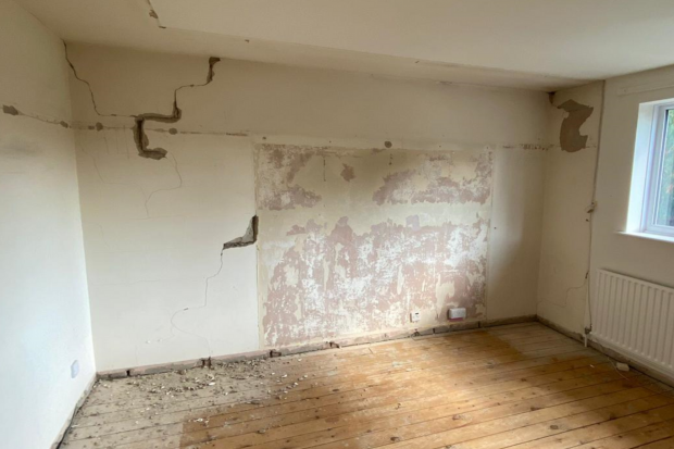 Interior house wall with cracked and damaged plaster board. 